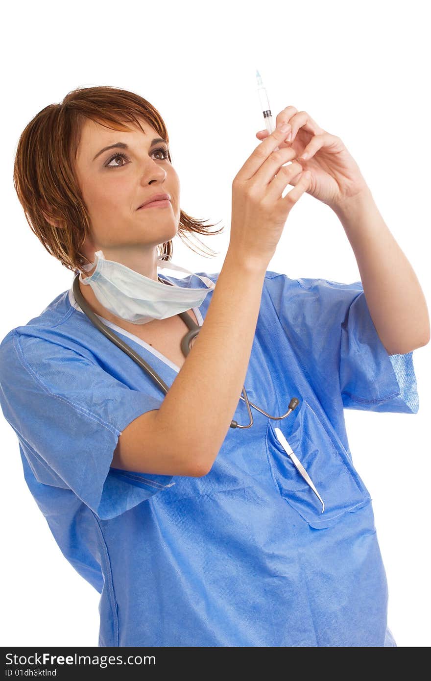 Attractive young female Caucasian doctor holding up and inspecting a filled syringe for air bubbles. Attractive young female Caucasian doctor holding up and inspecting a filled syringe for air bubbles