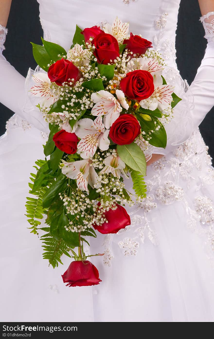 Against a wedding dress a beautiful bouquet of the bride.