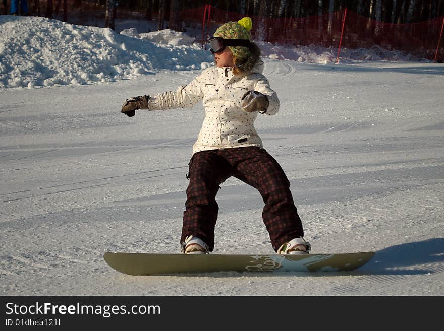 Snowboard girl on the slope in winter.