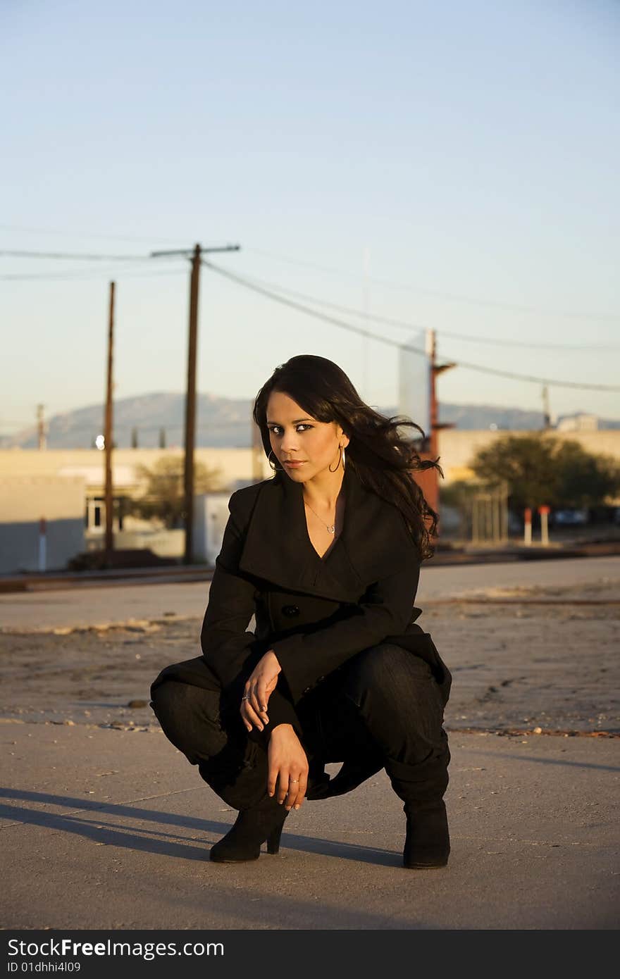 Beautiful woman iwearing black trenchcoat in urban setting. Beautiful woman iwearing black trenchcoat in urban setting