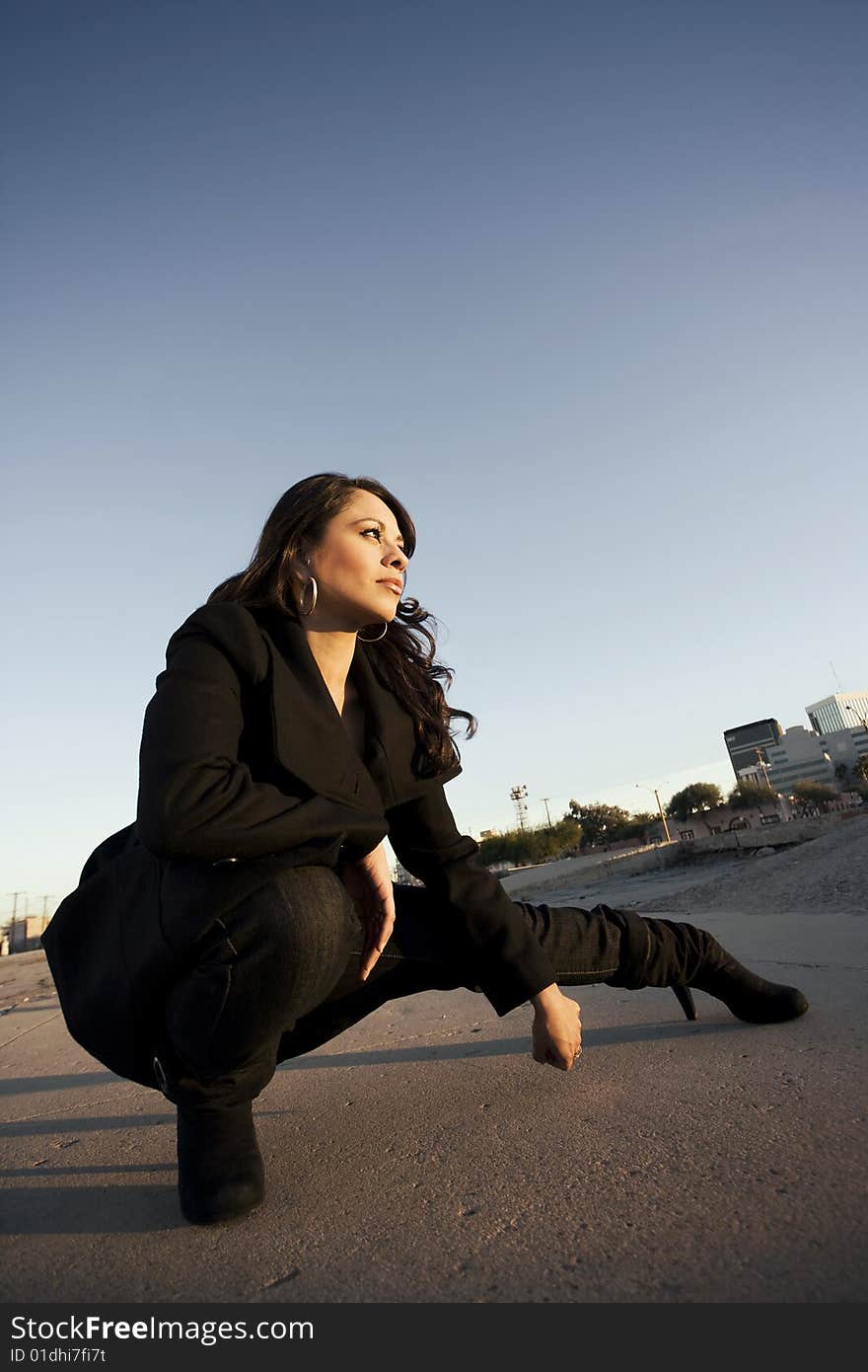 Beautiful woman wearing black trenchcoat in urban setting. Beautiful woman wearing black trenchcoat in urban setting