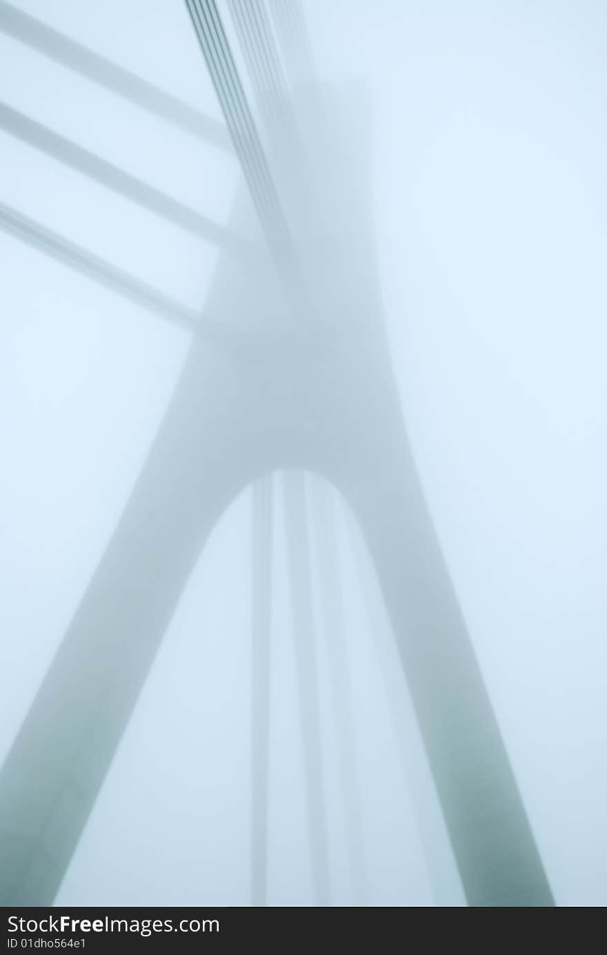 Industrial constructions are in fog, details of bridge are in a grey color