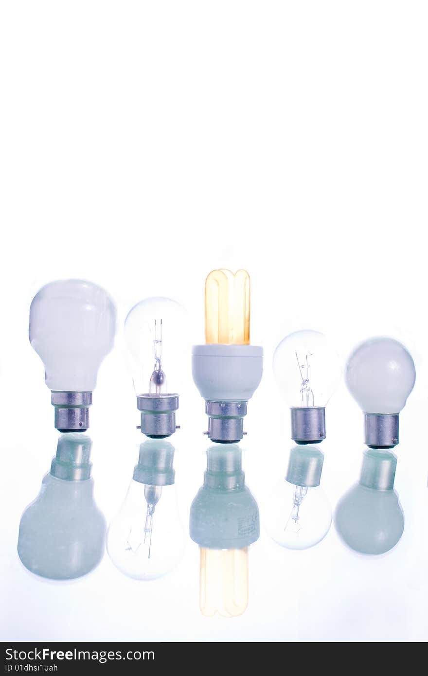 A row of assorted bulb with a lighted energy bulb central. A row of assorted bulb with a lighted energy bulb central