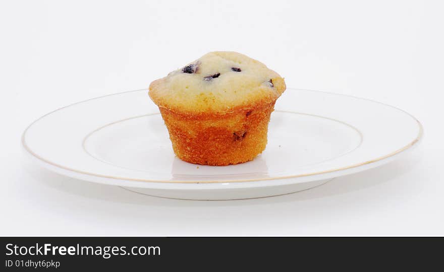 A blueberry muffin on plate, isolated on white