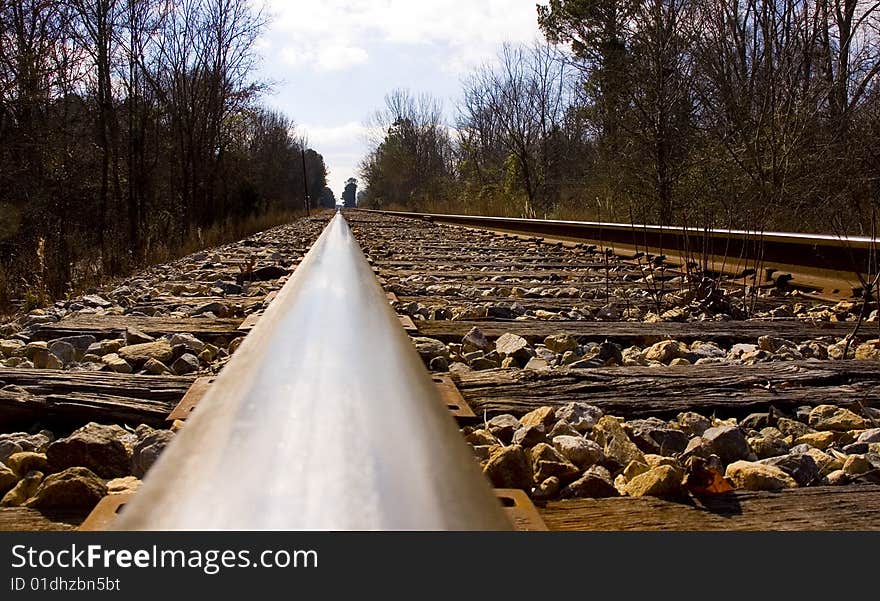 Looking down the rail of a railroad track.  Cross ties and gravel are visible. Looking down the rail of a railroad track.  Cross ties and gravel are visible.