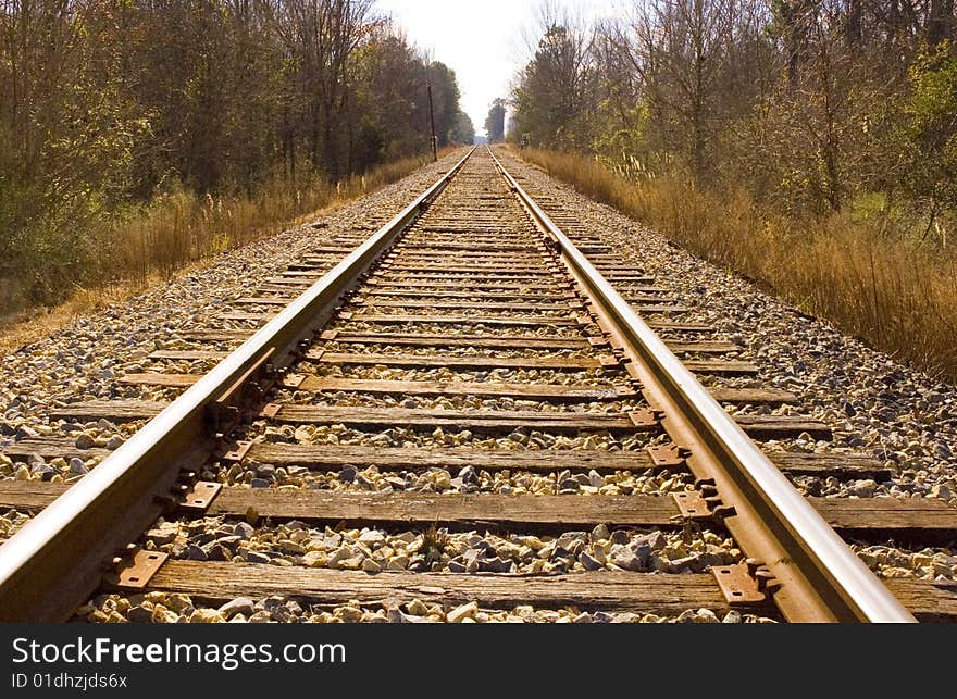 Looking down the rail of a railroad track. Cross ties and gravel are visible. Looking down the rail of a railroad track. Cross ties and gravel are visible.