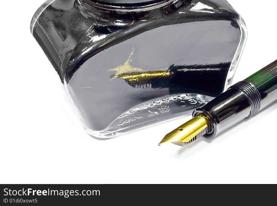 A jar of black writing ink and fountain pen. A jar of black writing ink and fountain pen