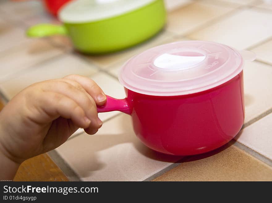 Baby's hand taking a food pot alone