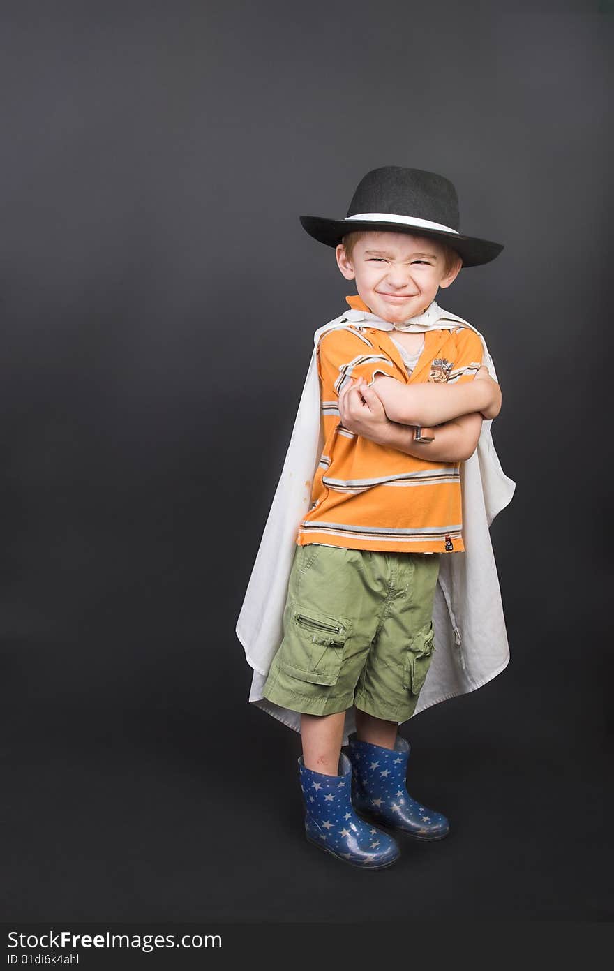 Young boy playing dressed up in hat and cape. Young boy playing dressed up in hat and cape