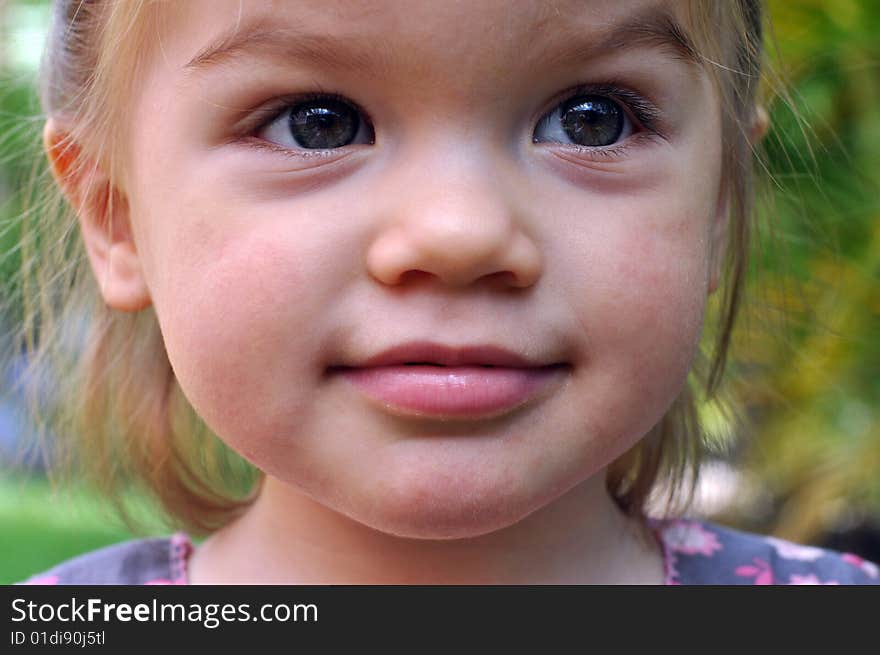 Little girl pulling funny faces and making the sound of a car