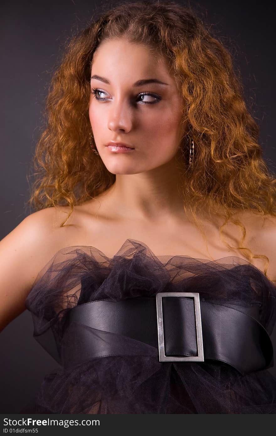 Portrait of a beautiful red-haired girl in belt