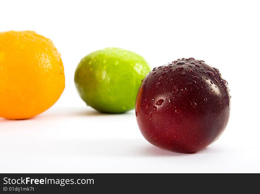 Orange, lemon, apple and plum on white background