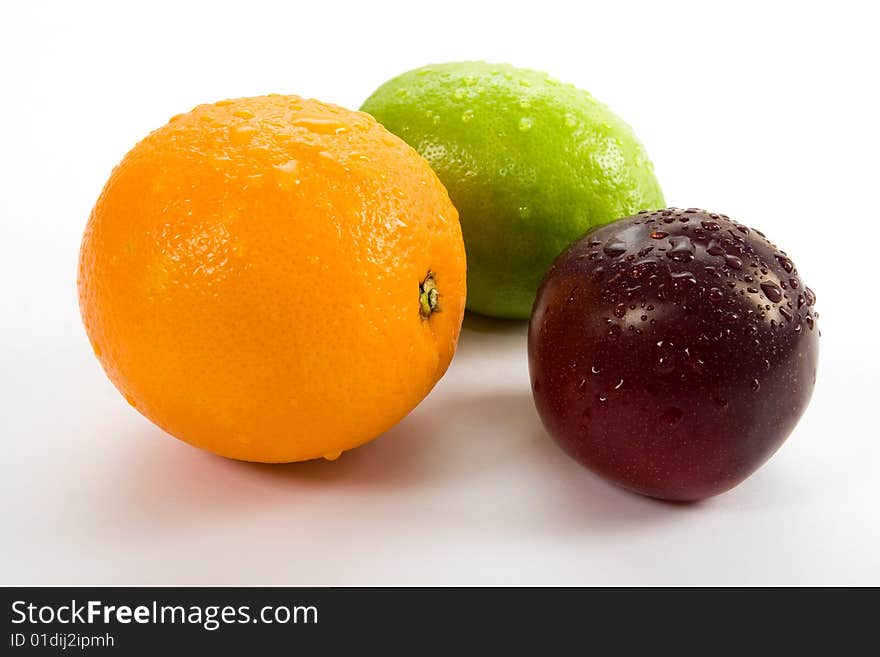 Lemon, orange and plum on white background