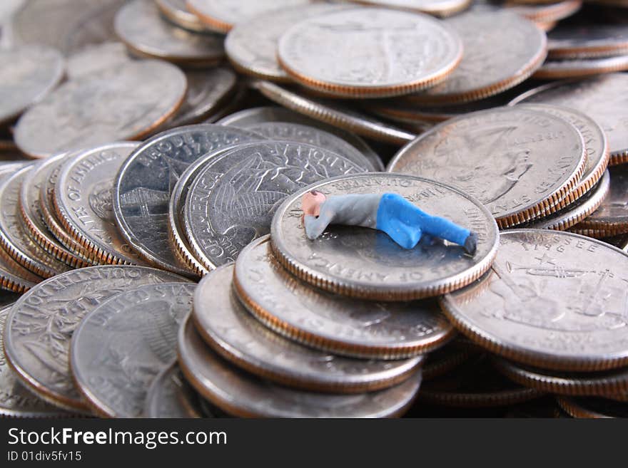 Miniature man sleeping on pile of quarters. Miniature man sleeping on pile of quarters