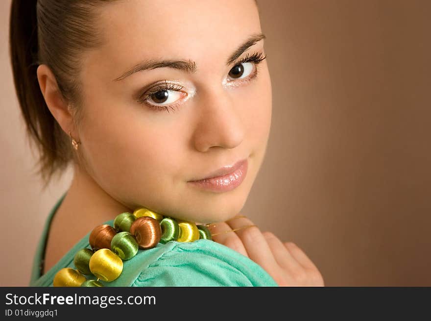 The beautiful young woman with a beads in a hand