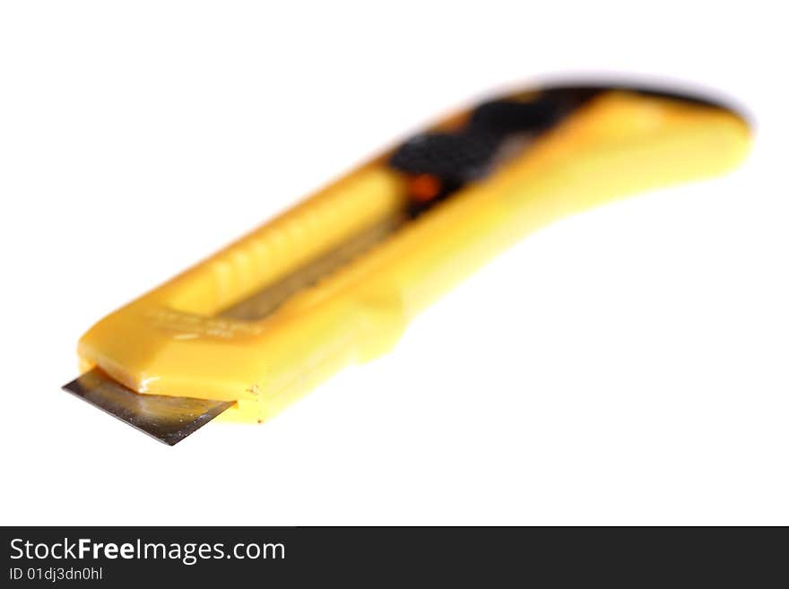 Sharp retractable utility knife with yellow plastic handle. Isolated on the white background. Narrow depth of field. Sharp retractable utility knife with yellow plastic handle. Isolated on the white background. Narrow depth of field.