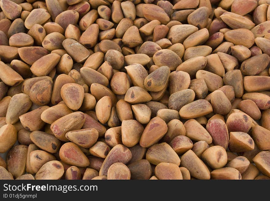 Many the crude pine nuts, on background