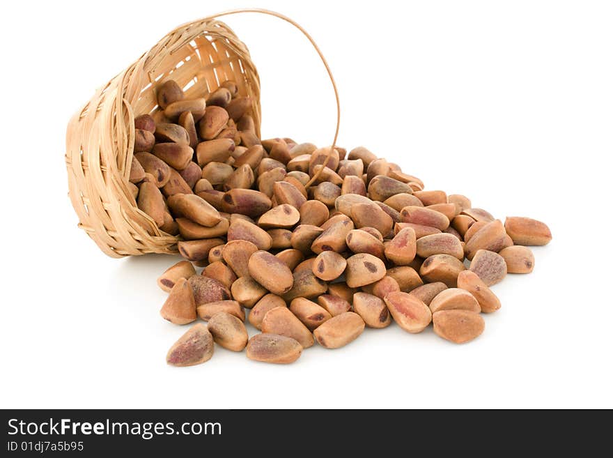 The crude pine nuts in a basket on a white background