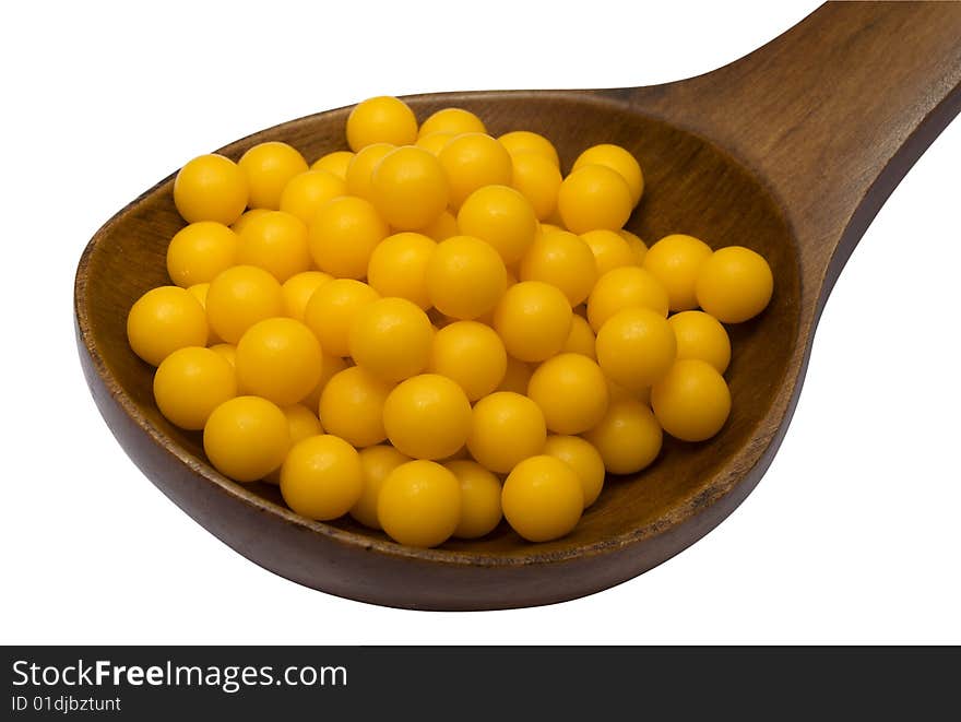 Pills in a wooden brown spoon on a white background it is isolated. Pills in a wooden brown spoon on a white background it is isolated