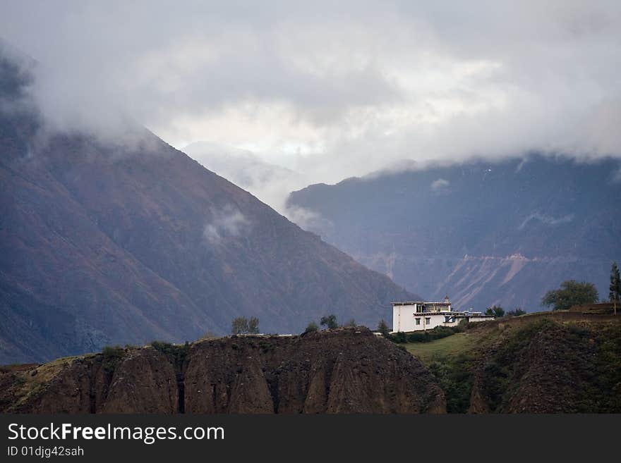 There is a house under mountains