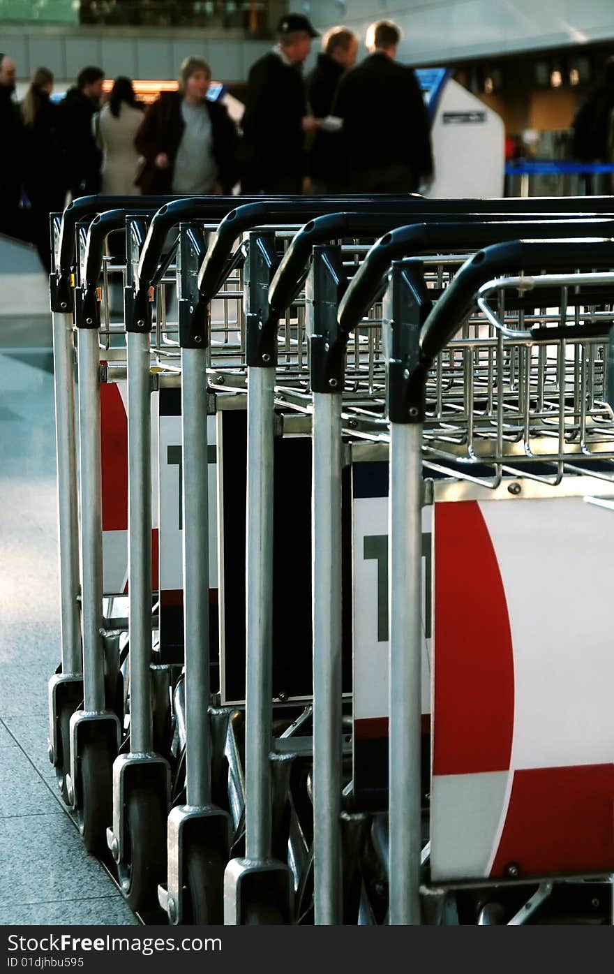 Trolleys in a row in front of passengers at an airport