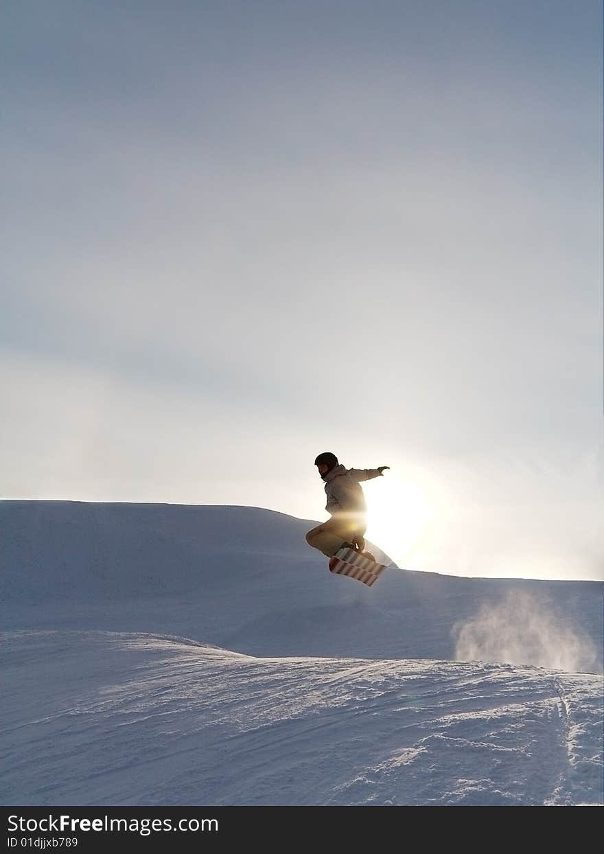 Snowboarder s jump at the sunset