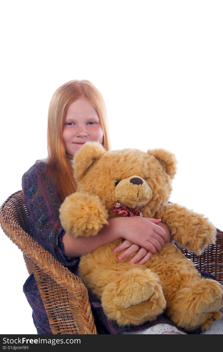 Redhead girl and her big toy bear are sitting in the armchair