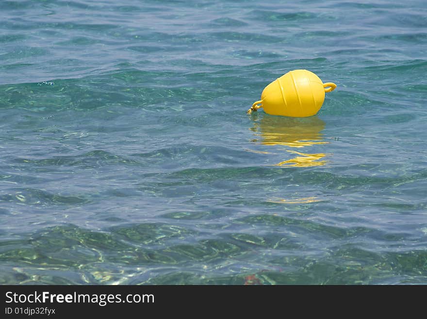 Yellow Buoy On Clear Blue Sea (room For Text)