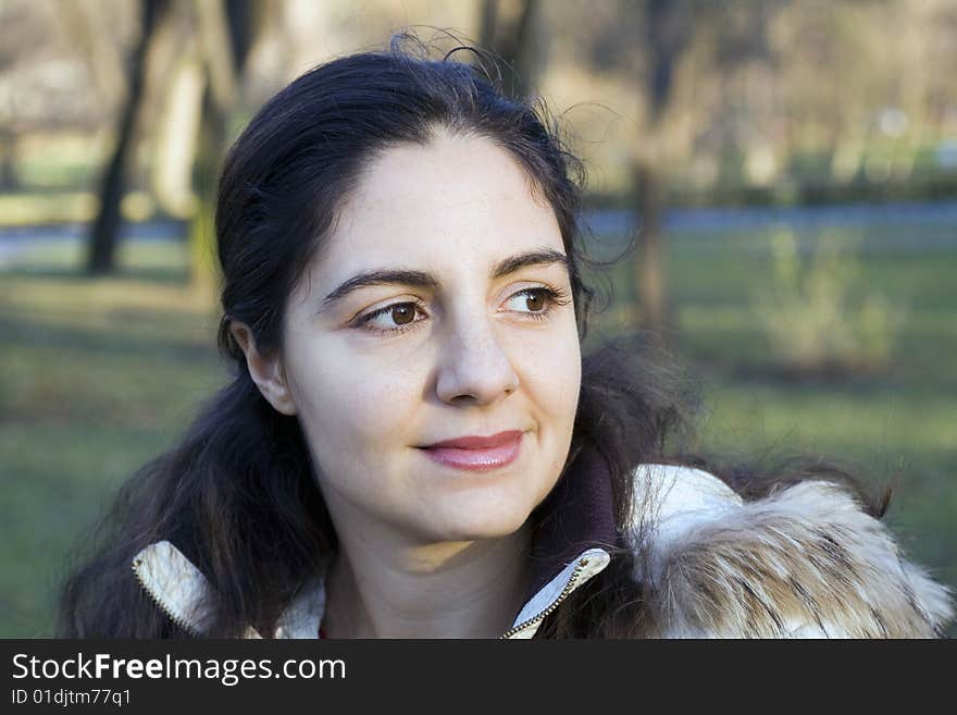 Young, beautiful woman, sitting in a park, looking at the distance. Young, beautiful woman, sitting in a park, looking at the distance