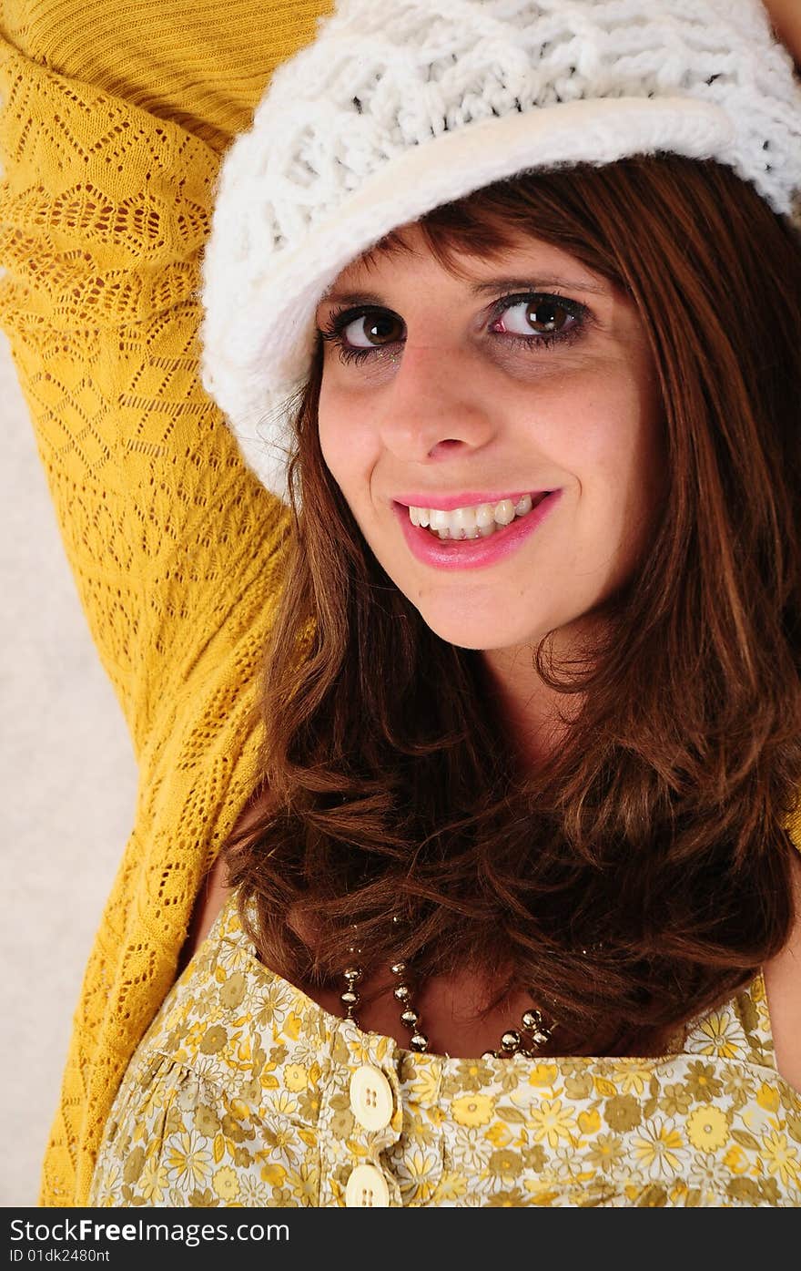 Lovely head shot of a female in a white knitted hat. Lovely head shot of a female in a white knitted hat