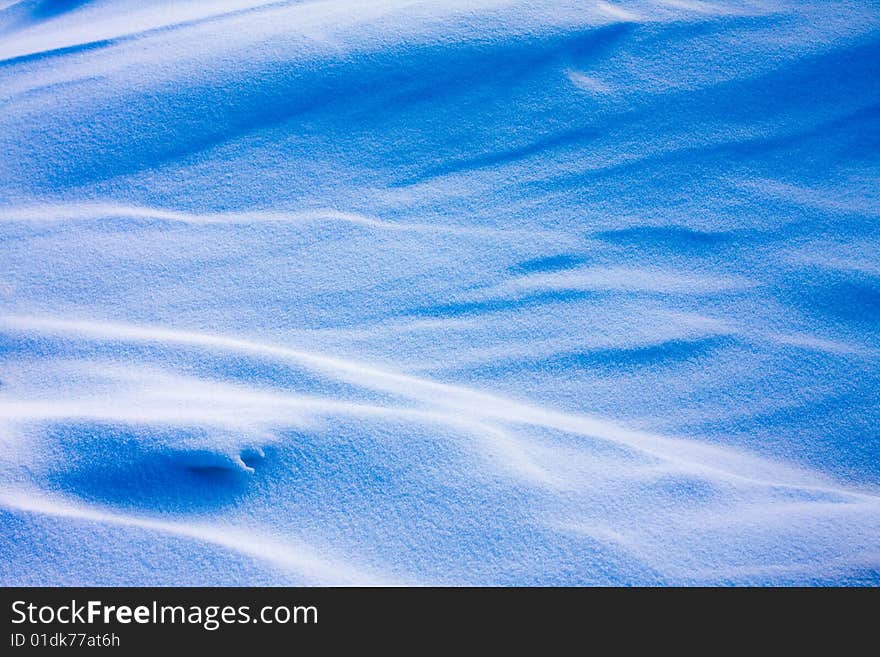 Shadow and light on the snowfield in a cold day