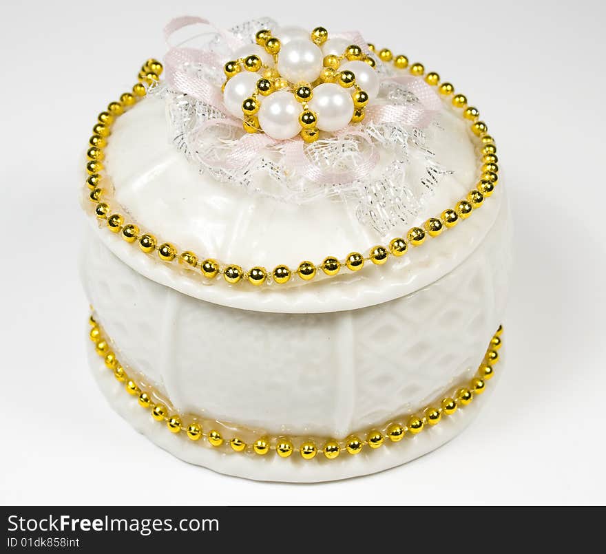 White round box with costume jewellery and ornamen