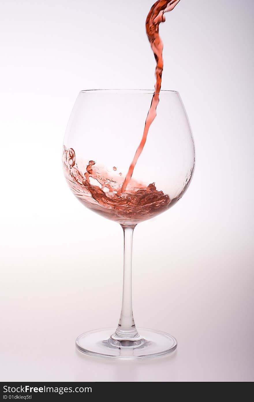 Red wine flow in a transparent glass