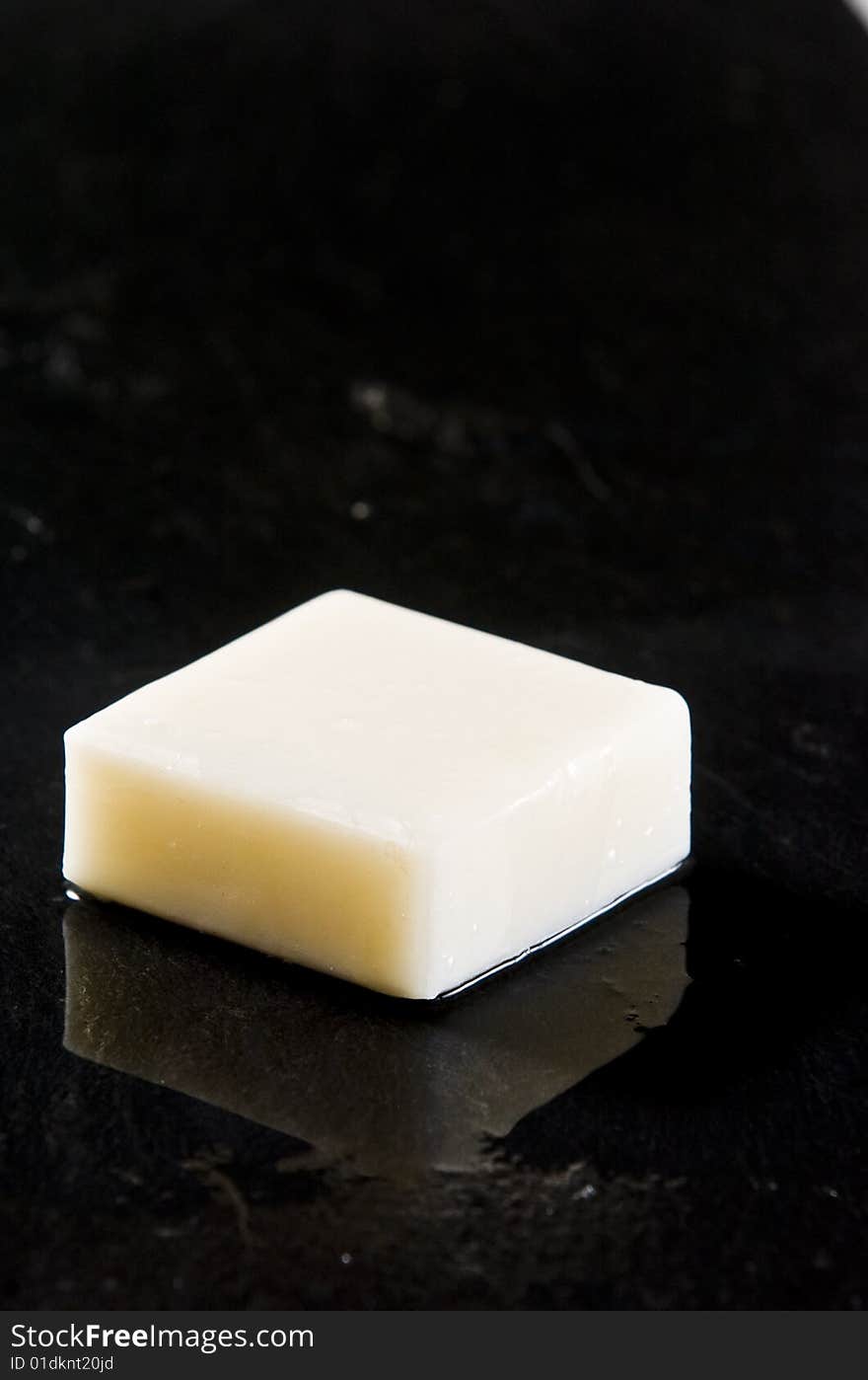 Bar of white soap on wet black slate