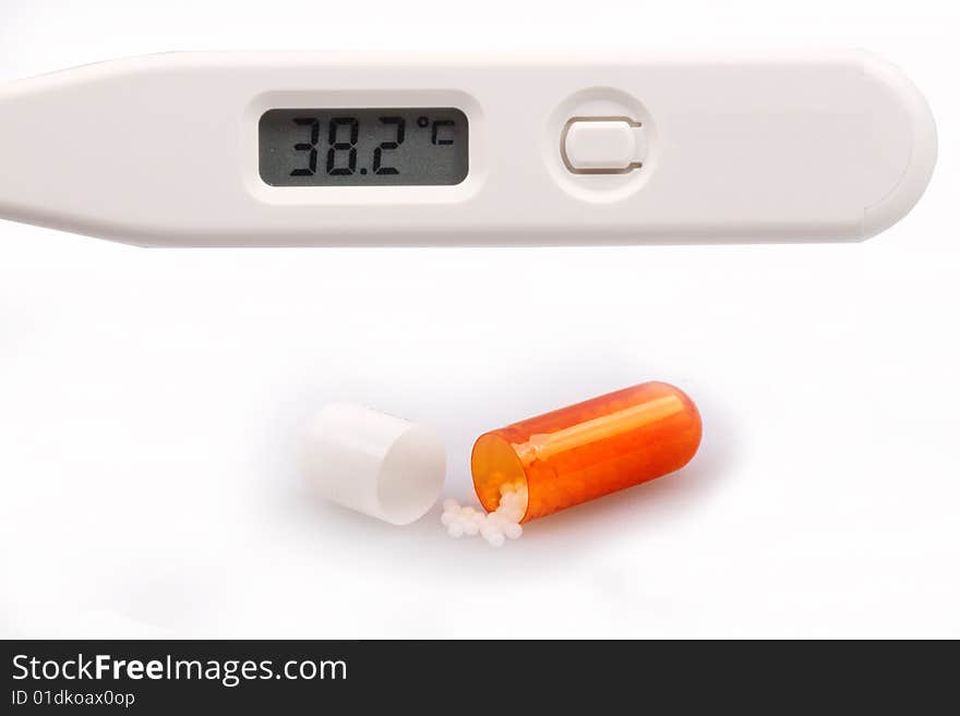 Digital thermometer and capsules medicine on white background.