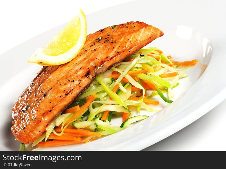 Fillet of Salmon with Julienne Peeler Vegetable and Lemon Slice. Isolated on White Background