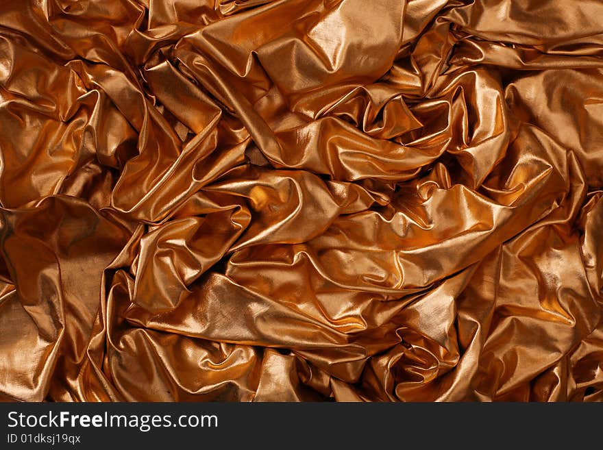 Abstract gold silk background with folds. Abstract gold silk background with folds