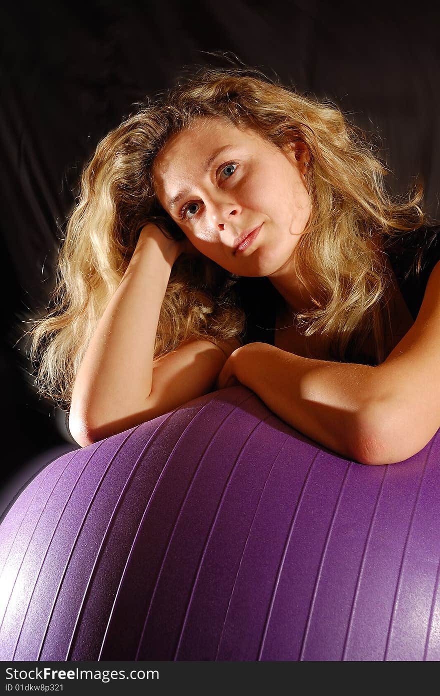 Portrait of a beautiful young woman lying on a big fitness ball. Portrait of a beautiful young woman lying on a big fitness ball