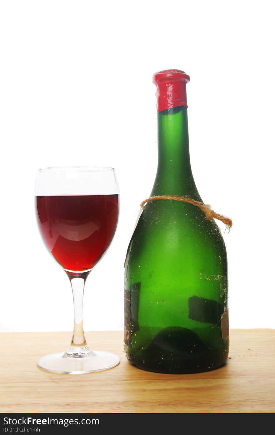 Glass of red wine and a green wine bottle. Glass of red wine and a green wine bottle