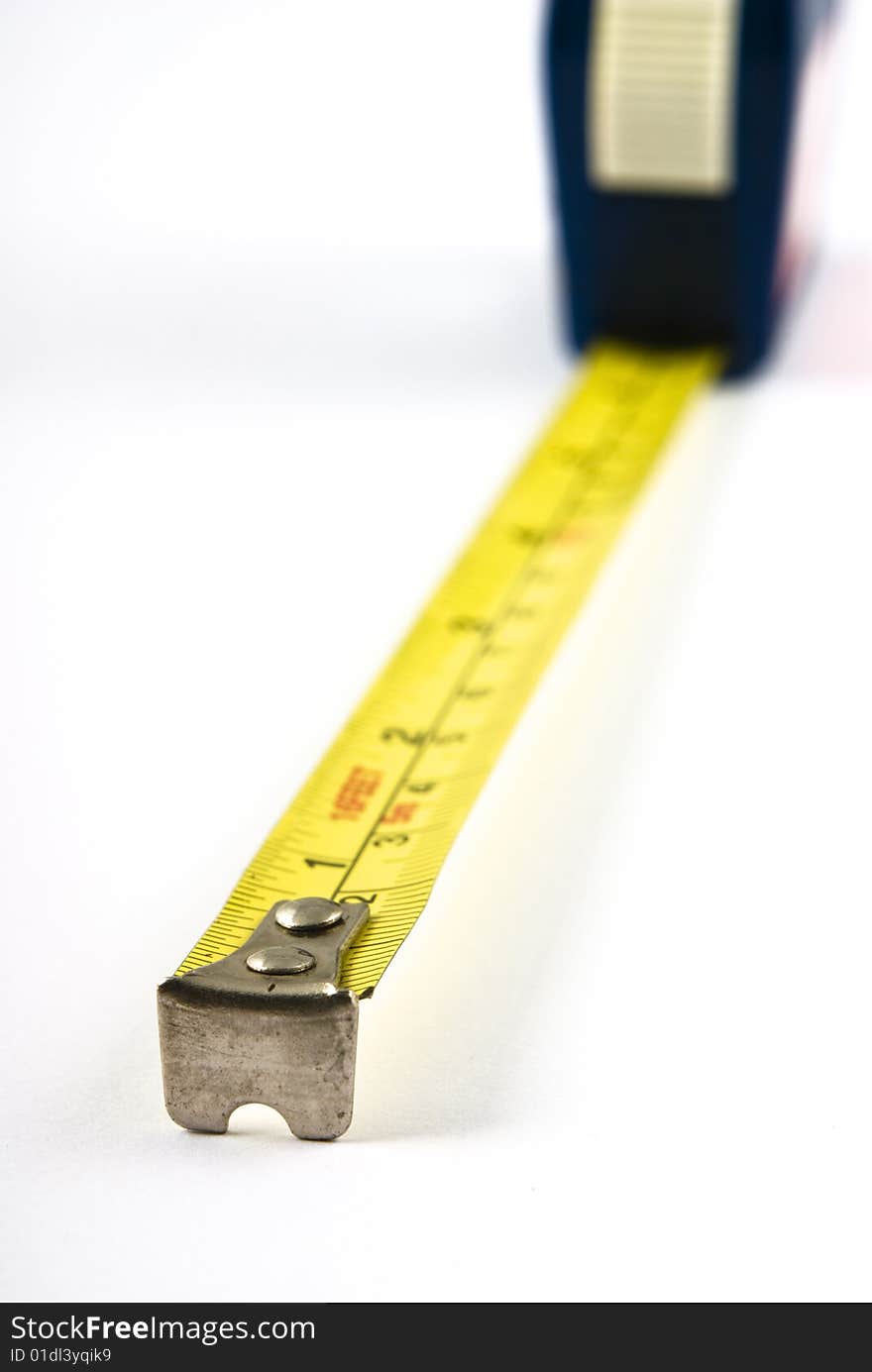 Measuring tape extended towards viewer with very shallow depth of field. Isolated on white. Measuring tape extended towards viewer with very shallow depth of field. Isolated on white.