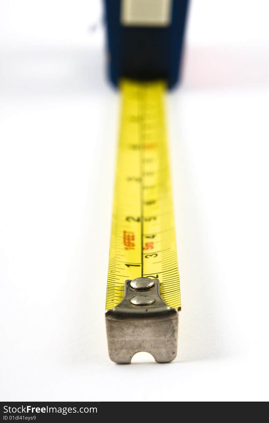 Measuring tape extended towards viewer with very shallow depth of field. Isolated on white. Measuring tape extended towards viewer with very shallow depth of field. Isolated on white.