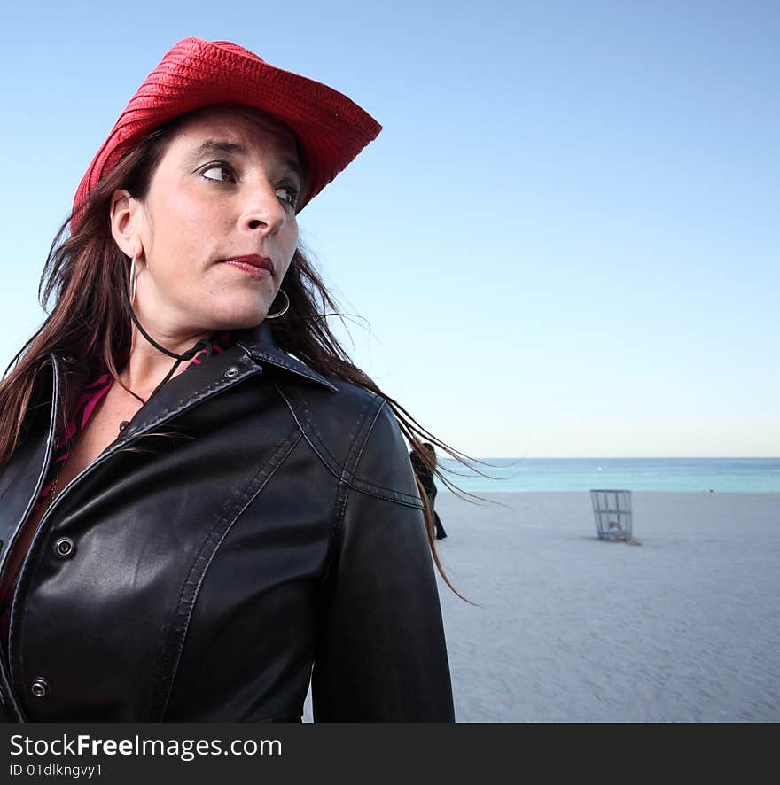 Adult on the beach wearing a red cowboy hat. Adult on the beach wearing a red cowboy hat