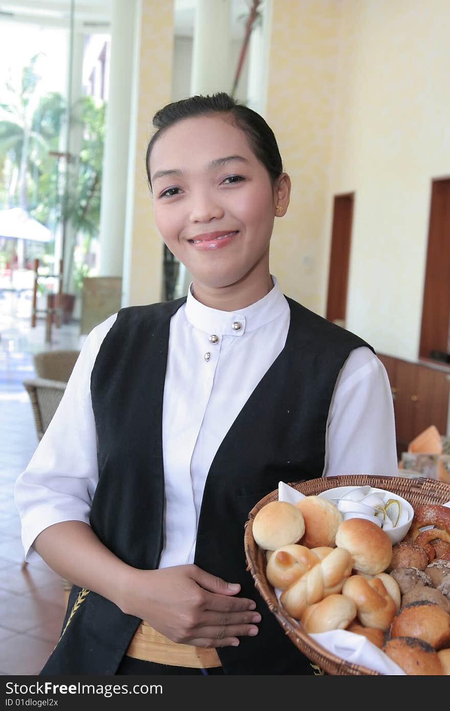 Waitress at work holding bread basket smiling