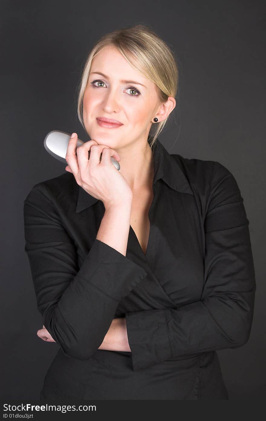 Composed Businesswoman holding a phone against a black background. Composed Businesswoman holding a phone against a black background