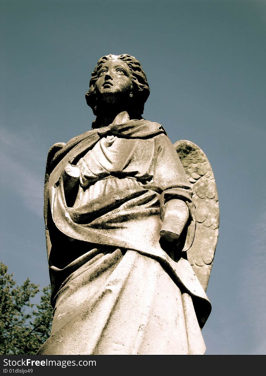 A beautiful, solitary angel of stone stands guard over loved ones forever.  Her missing left hand abruptly interrupts the intensity of the love this beautiful sculptured angel emits. A beautiful, solitary angel of stone stands guard over loved ones forever.  Her missing left hand abruptly interrupts the intensity of the love this beautiful sculptured angel emits.