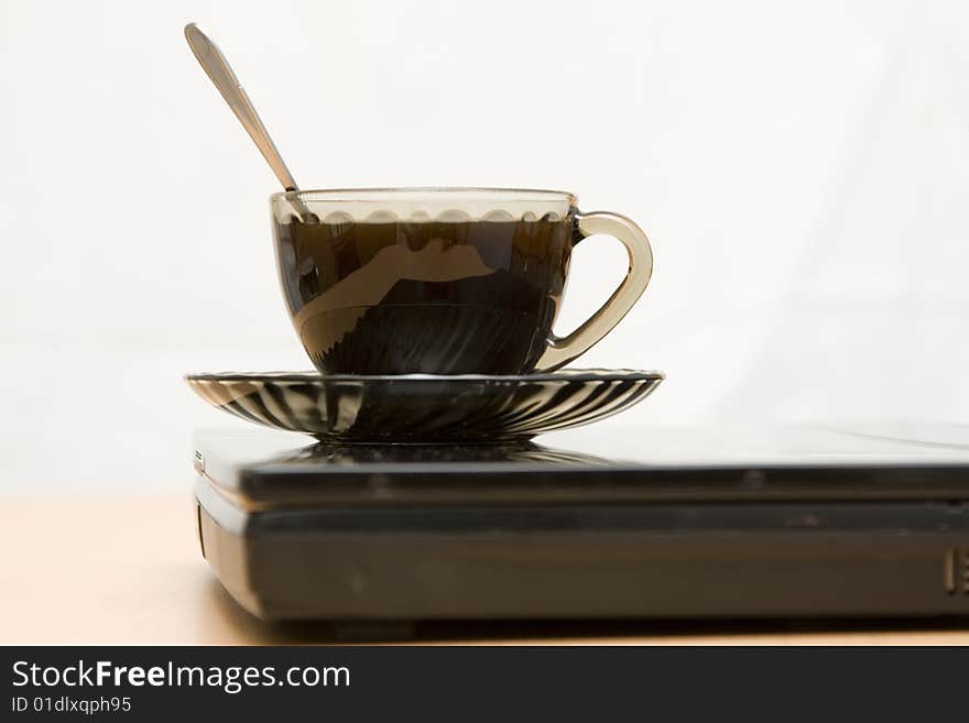 Espresso coffee cup with steel spoon on the laptop