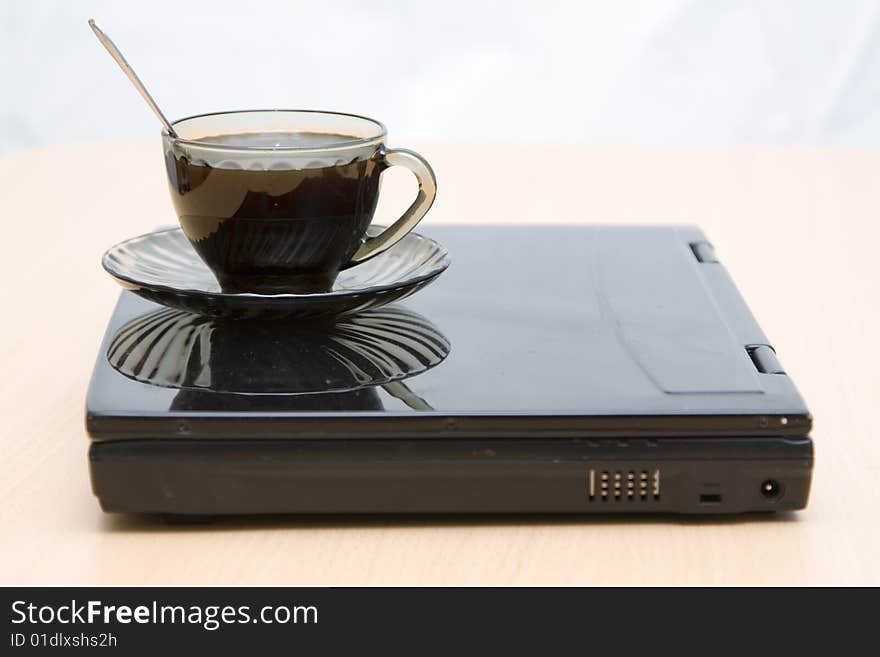 Espresso coffee cup with steel spoon on the laptop