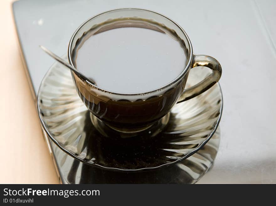 Espresso coffee cup with steel spoon on the laptop