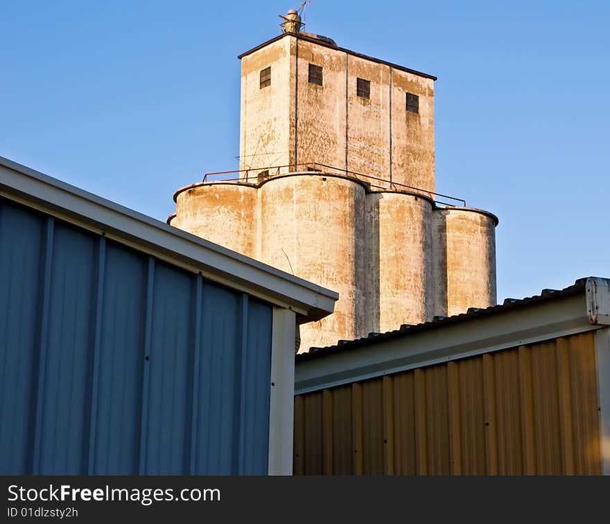 Grain silo behind two colorful buildings