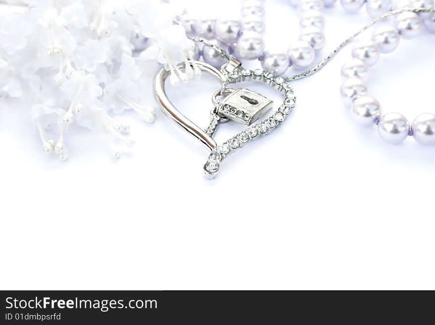 Silver heart with key,lock,pearls and flowers on white background.